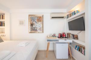 a white room with a desk and a tv at A Room with a View in Athens