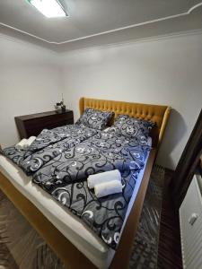 a bedroom with a bed with a black and white comforter at APARTMAN WOLF Luxusné priestranné ubytovanie s Výhľadom na hory s Bezplatným Parkovaním Veľkou SMART TV Rýchlym Optickým Internetom Priamo v PB Tichá lokalita Všetko na blízku Vhodné pre Rodinu Skupinu Pracovné cesty aj Turistiku Plne vybavená Kuchyňa in Považská Bystrica +65 photos