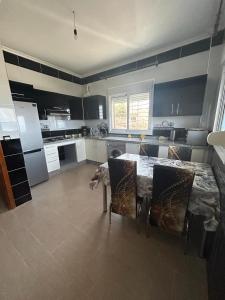 a kitchen with a table and chairs in it at Appartement à Houma, proche Port Tanger Med in Dalia