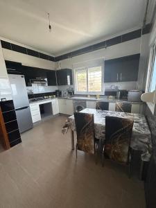 a large kitchen with a table and chairs in it at Appartement à Houma, proche Port Tanger Med in Dalia