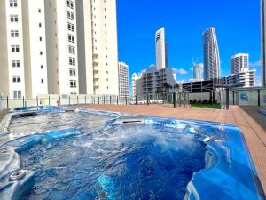 黄金海岸Ocean View studio in Mantra Free WI-FI的一座高楼城市中心的一个热水浴缸
