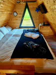 Cabana Lupul din Apuseni في Mătişeşti: سرير كبير في غرفة خشبية مع نافذة