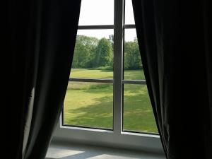 a window with a view of a green yard at Schloss Altenhagen in Kröpelin