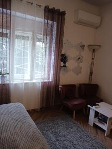 een slaapkamer met een bed, een stoel en een raam bij Studio Luna in Opatija