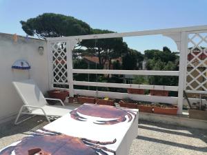 a balcony with a chair and a table and a view at Casa di Clara Fregene in Fregene +3 photos