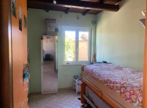 a bedroom with a bed and a window and a mirror at Casa di Clara Fregene in Fregene