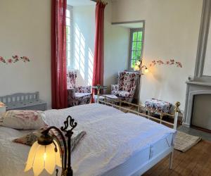 a bedroom with a bed and two chairs and a fireplace at Château Planquery - Viking Heritage, Pet Friendly in Planquery