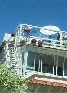 a white house with stairs and flowers on it at Casa di Clara Fregene in Fregene