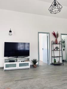een woonkamer met een grote flatscreen-tv bij Casa Dom Simões in Aljezur