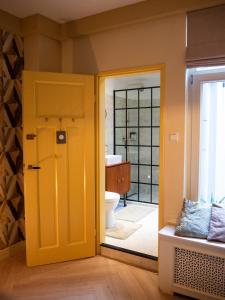 a bathroom with a yellow door and a toilet at BnB 117 in Amsterdam