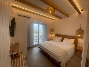 een slaapkamer met een bed en uitzicht op het water bij SOHOROS suites in Skhoinoussa