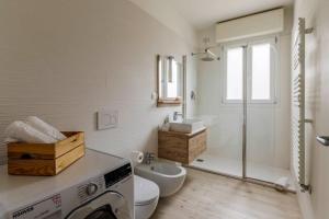 a bathroom with a sink and a washing machine at Brand new 3 bedrooms apartment in Navigli area in Milan