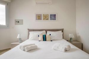 a bedroom with a white bed with towels on it at Brand new 3 bedrooms apartment in Navigli area in Milan
