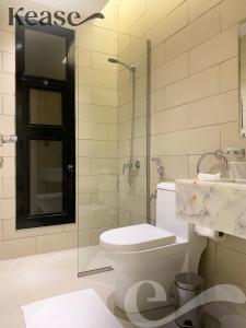 uma casa de banho com um WC e uma cabina de duche em vidro. em Kease Tawun A5-2 Royal touch Terrace XZ48 em Riyadh