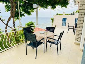 a table and chairs on a balcony with the ocean at Sea Breeze Apartments in Starigrad-Paklenica