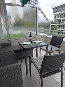 un tavolo con sedie e una bottiglia di vino sul balcone di Cozy apartment in Edificio Bahamas a Puerto de la Cruz
