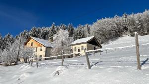 una casa en una colina cubierta de nieve con árboles en Relais de la Baume, en Le Locle