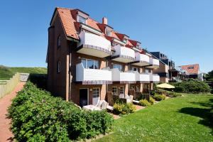 a large brick building with a lawn in front of it at Haus Nordstrand in Norderney