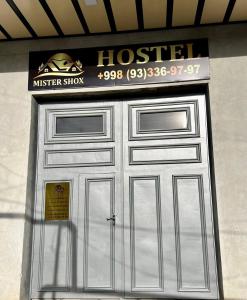 metalowe drzwi garażowe z znakiem hotelowym nad nimi w obiekcie MrShox Hostel w Samarkandzie