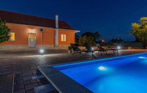 una piscina frente a una casa por la noche en Iris Holiday home en Trbounje