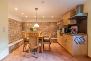 a kitchen with a table and chairs and a brick wall at Villa Stock Wohnung VS 5 im Souterrain in Heringsdorf
