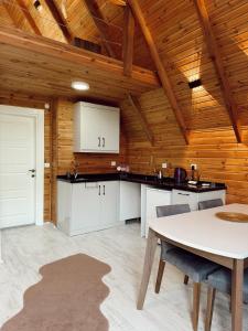 a kitchen with a table and a wooden ceiling at Hidden Garden Bungalow in Trabzon