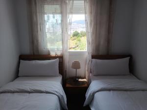 two beds in a room with a window at The Oxygen 7 in Tetouan