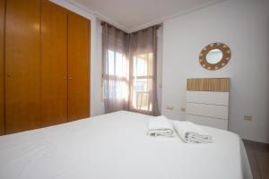 a bedroom with a white bed and a window at Patacona deluxe primera linea in Valencia