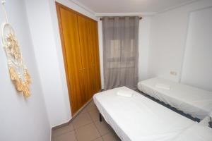 a small room with two beds and a door at Patacona deluxe primera linea in Valencia