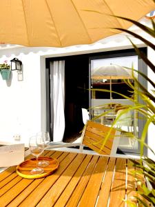 Marbella Village في مربلة: طاولة خشبية مع كأس نبيذ ومظلة