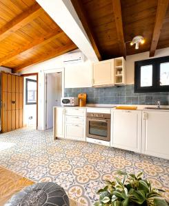 a kitchen with white cabinets and a tile floor at Marbella Village in Marbella