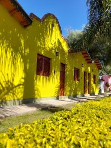 a yellow building with a palm tree in front of it at Cabañas Puertas del Sol in La Rioja