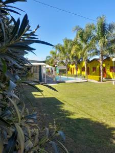 a green yard with houses and palm trees at Cabañas Puertas del Sol in La Rioja