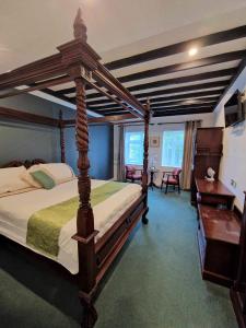 una camera con un grande letto in legno di The Lanterns Hotel a Tarbert