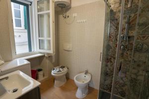 a bathroom with a toilet and a sink and a shower at La finestra sul teatro in Alghero