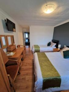 una camera d'albergo con due letti e un tavolo di The Lanterns Hotel a Tarbert