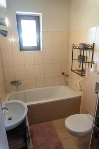 a bathroom with a tub and a toilet and a sink at Rusztikus Nyaralóház in Szigliget +9 photos