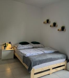 - une chambre avec un lit et 2 étagères sur le mur dans l'établissement Mini Apartament Pod 13, à Polanica-Zdrój