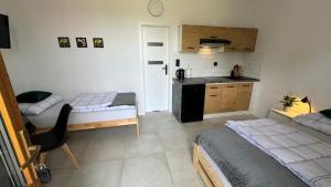 une petite chambre avec deux lits et une cuisine dans l'établissement Mini Apartament Pod 13, à Polanica-Zdrój