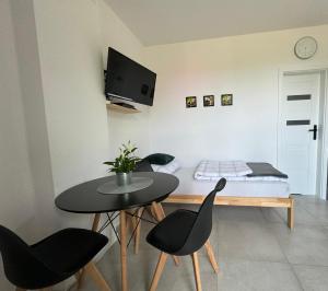 a room with a table and chairs and a bed at Mini Apartament Pod 13 in Polanica-Zdrój