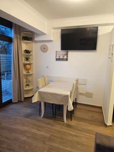 ein Esszimmer mit einem Tisch und einem Flachbild-TV in der Unterkunft Langust - free parking in Sveti Stefan