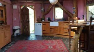a kitchen with wooden cabinets and a table with a counter at Tara vegetarian retreat guesthouse in Carmarthen +8 photos