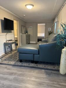 a living room with a blue couch and a tv at The Tides in Hampton