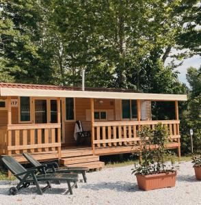 eine Holzhütte mit einer Veranda und einem Picknicktisch in der Unterkunft TuscanyChalets - luxe family chalet near sea with pool in Viareggio