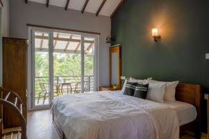 a bedroom with a bed and a large window at Dollyz Home - Sri Lanka in Ambalangoda