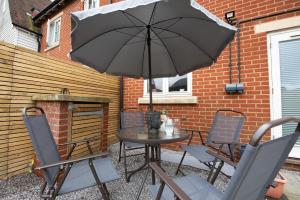 a table and chairs with an umbrella on a patio at 3 bedroom House, 2 Parking, Free WiFi, Modern Comfort in Colchester