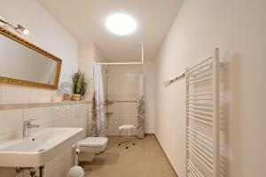 a white bathroom with a sink and a toilet at Bernsteinquartier Ferienwohnung Blaues Fenster in Kölpinsee +17 photos