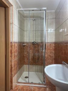 a bathroom with a shower and a tub and a sink at Pensiunea Olimp in Arad