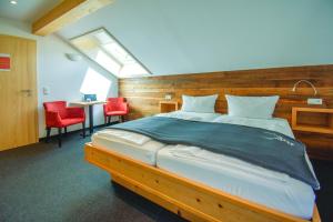 a bedroom with a large bed and red chairs at Das Kleemanns - Nur für Erwachsene in Mittelberg
