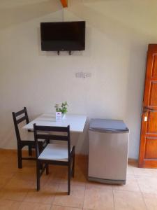 Habitación con mesa, 2 sillas y TV. en Cabañas Puertas del Sol en La Rioja
